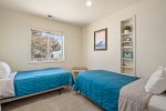 The third bedroom located on the third floor of the home includes two twin beds.